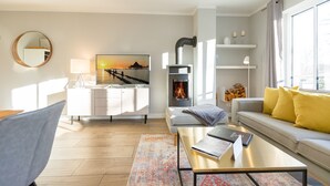 Een moderne woonkamer met een bank, salontafel en een open haard.