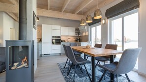 A modern kitchen with a central island, pendant lighting, and a large window. - Domicile Düne 8, App. 7 (Heringsdorf)