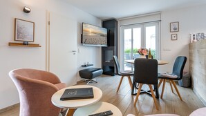 Ein modernes Wohnzimmer mit einer Couch, einem Couchtisch und einem Essbereich mit Stühlen und einem Tisch.