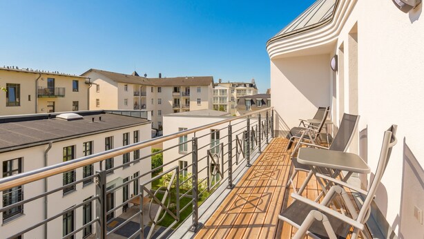 A balcony with a view of neighboring buildings, a railing, and outdoor furniture. - Quartier am Kurpark, app. 08 (Heringsdorf)