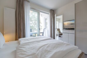 Une chambre d’hôtel avec un grand lit, une télévision et une vue sur l’extérieur.