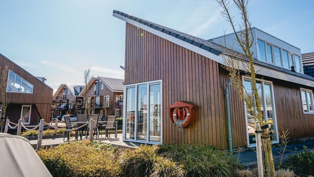 A modern building with large windows and a wooden facade. - House by Uitgeestermeer with Garden (Uitgeest)