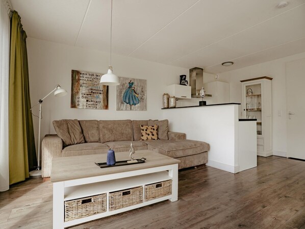 A modern living room with a sectional sofa, a coffee table, and a dining area.