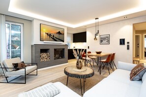 Uma sala de estar moderna com lareira, área de refeições e sofá.