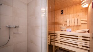 En sauna med glasdør, træbænke og trævæg.