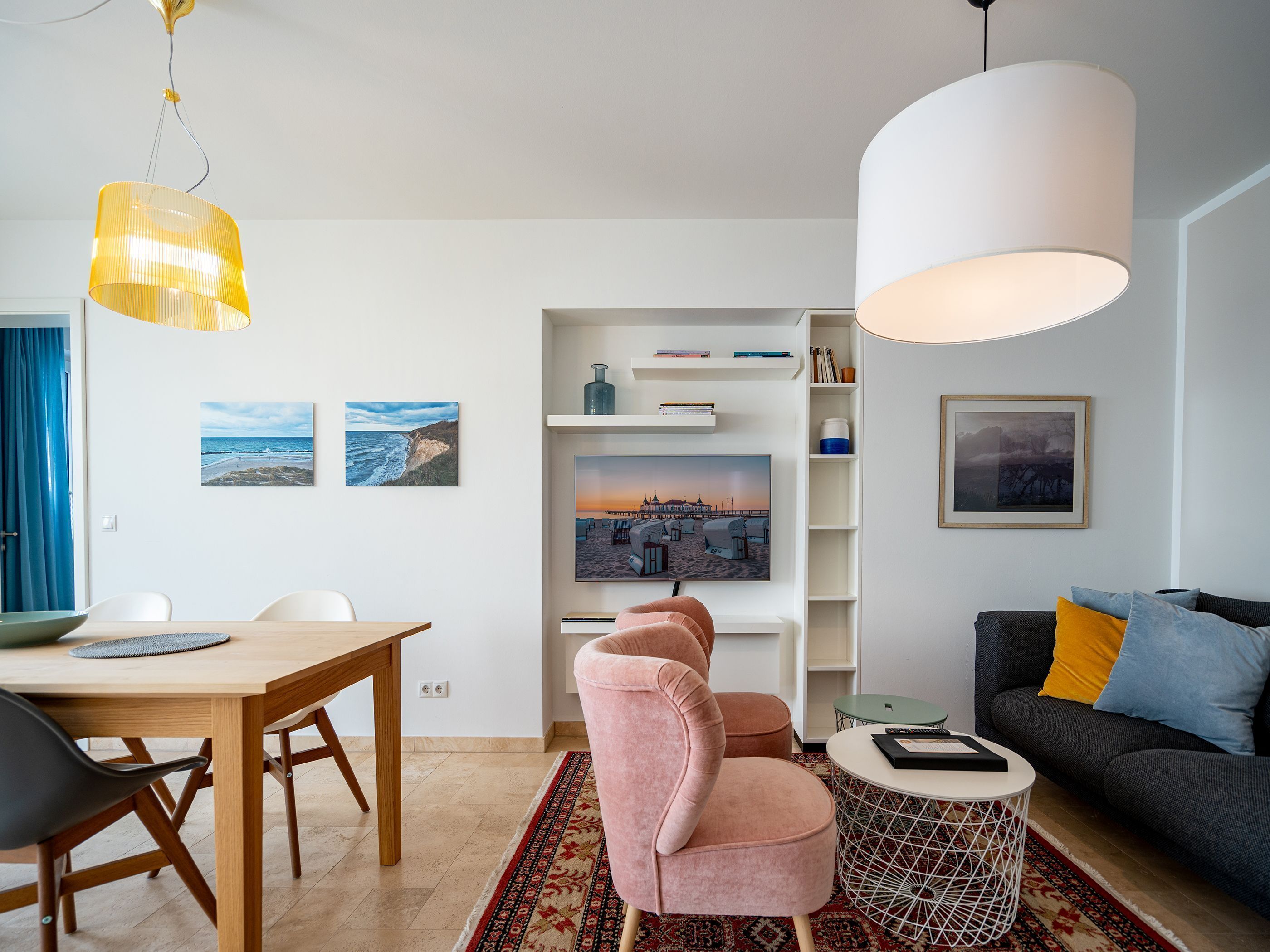 A modern living room with a dining area, featuring a sofa, a table, and a coffee table.