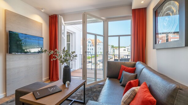 Una sala moderna con un sofá, una mesa de centro y un televisor.