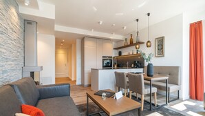 A modern living room with a sofa, a coffee table, and a dining area with chairs and a table. - Beachhouse Bansin, app. 22 (Heringsdorf)