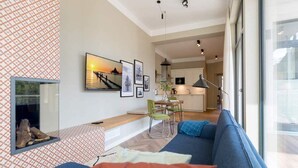 En moderne stue med en blå sofa, pejs og spiseplads med et bord og stole.