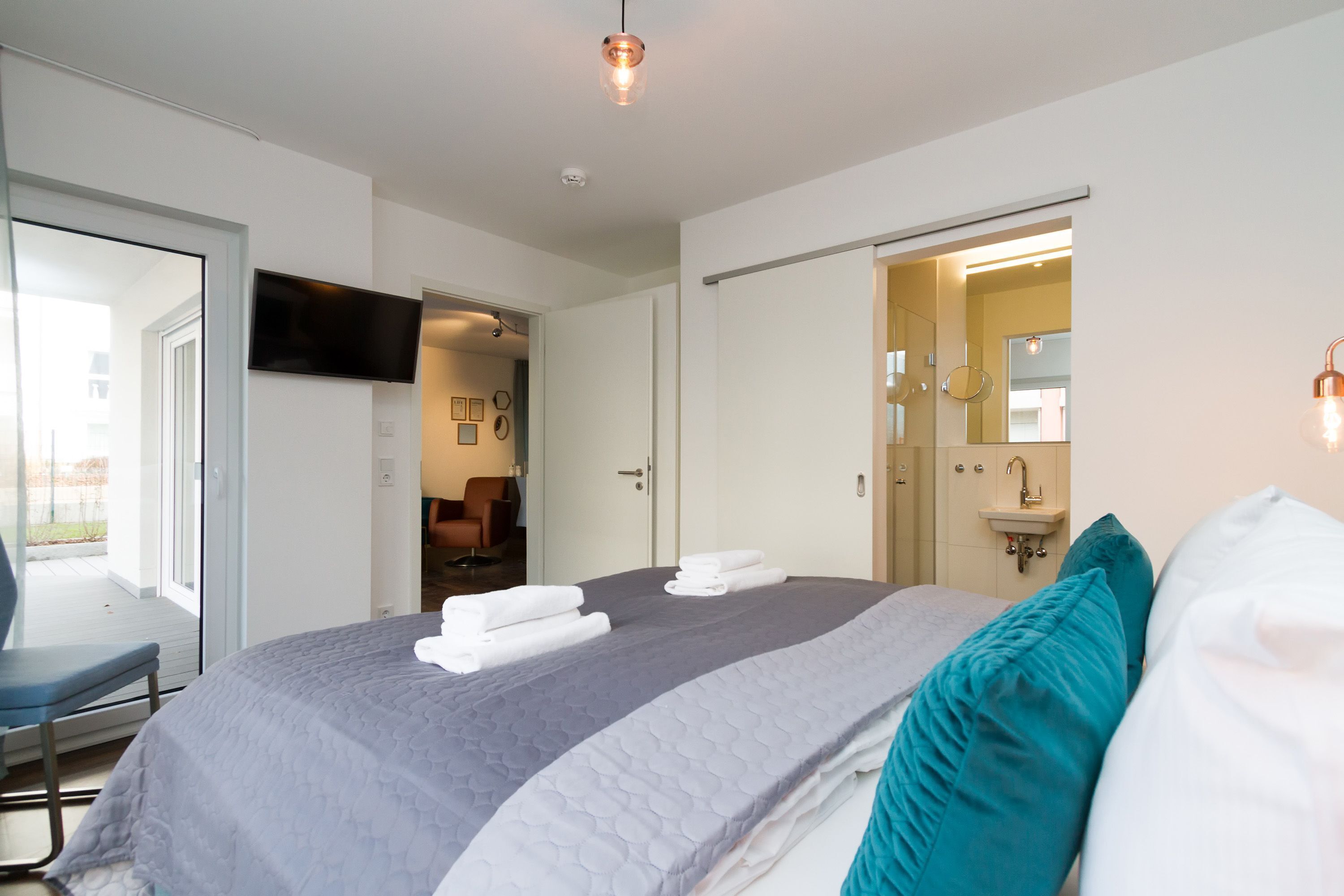 Una camera d'albergo moderna con un letto grande, una scrivania e una televisione.