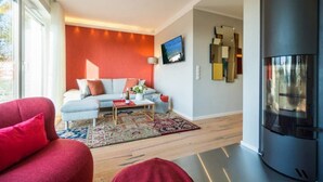A modern living room with a sofa, a coffee table, and a fireplace. - Quartier am Fischerstrand, app. 4 (Heringsdorf)