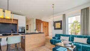 A modern living room with a sofa, a coffee table, and a kitchen area with a bar.