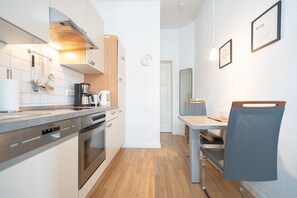 Una cocina moderna con electrodomésticos de acero inoxidable, encimera de madera y comedor con mesa y silla.