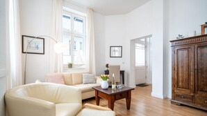 Un salon comprenant un canapé, une table basse, un meuble et des tableaux encadrés accrochés au mur.