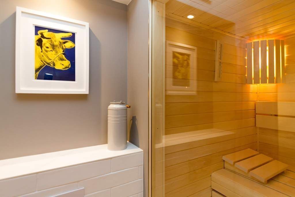 A sauna with wooden benches and a framed picture on the wall.