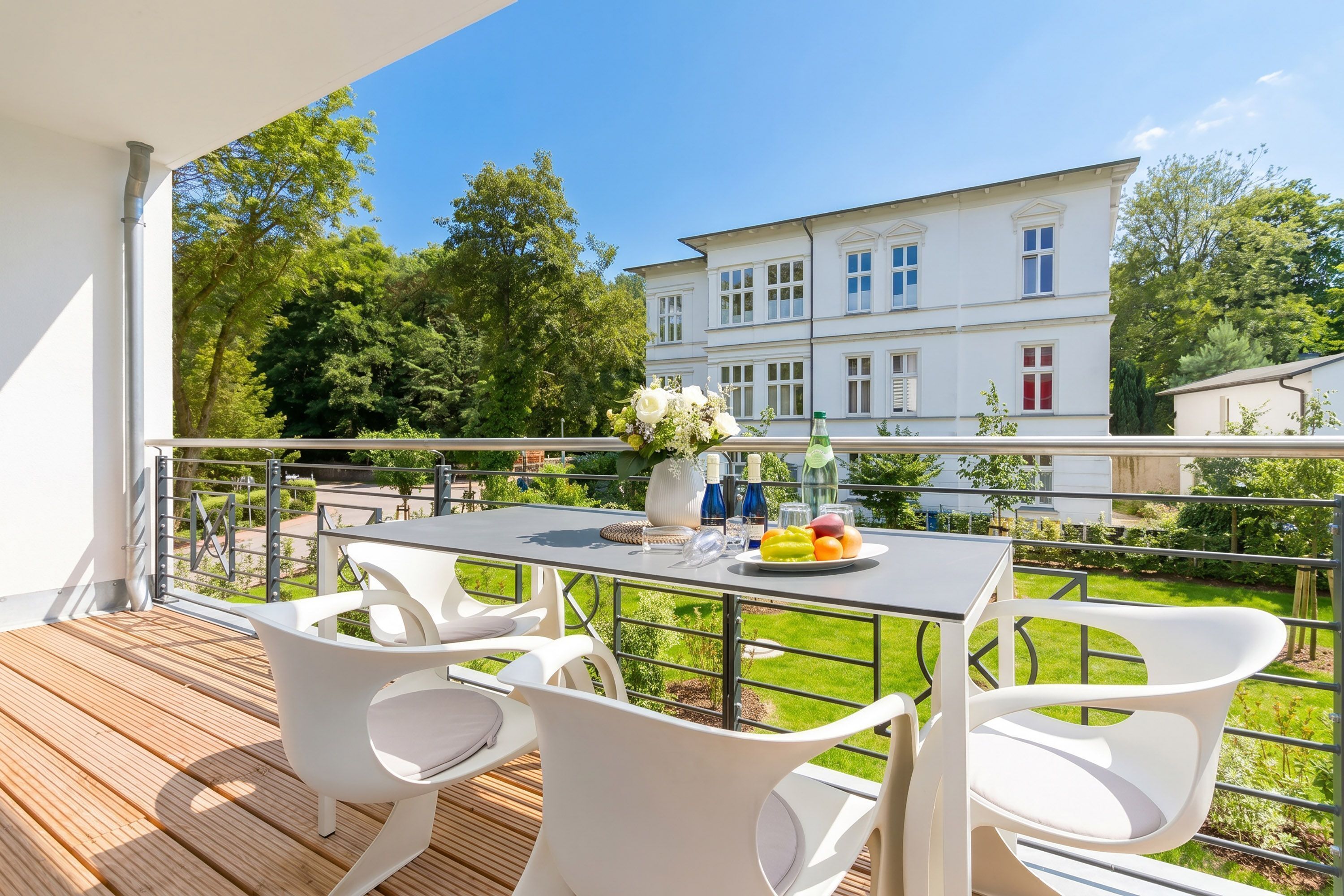 A balcony with a table, chairs, and a view of a building.