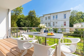 A balcony with a table, chairs, and a view of a building. - Villa Strandgrün, App. 05 (Heringsdorf)