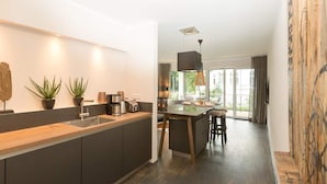 A modern kitchen with a wooden countertop, built-in appliances, and a large island. - Villa Strandgrün, App. 06 (Heringsdorf)