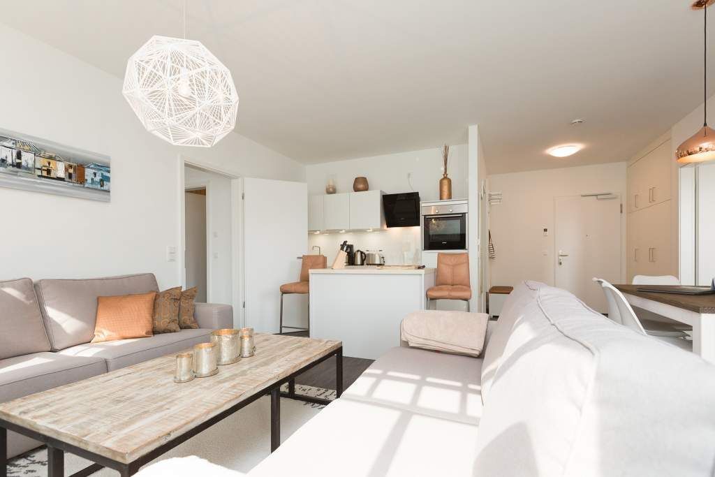 Een modern appartement met een zithoek, keuken en een eetgedeelte.