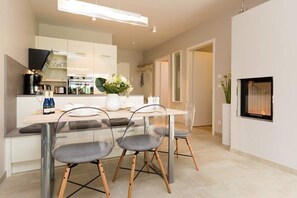 Uma cozinha moderna com uma ilha central, cadeiras transparentes e uma mesa de jantar.