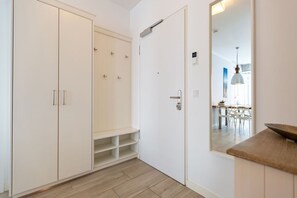 Una habitación con armario, puerta con espejo y encimera de cocina.