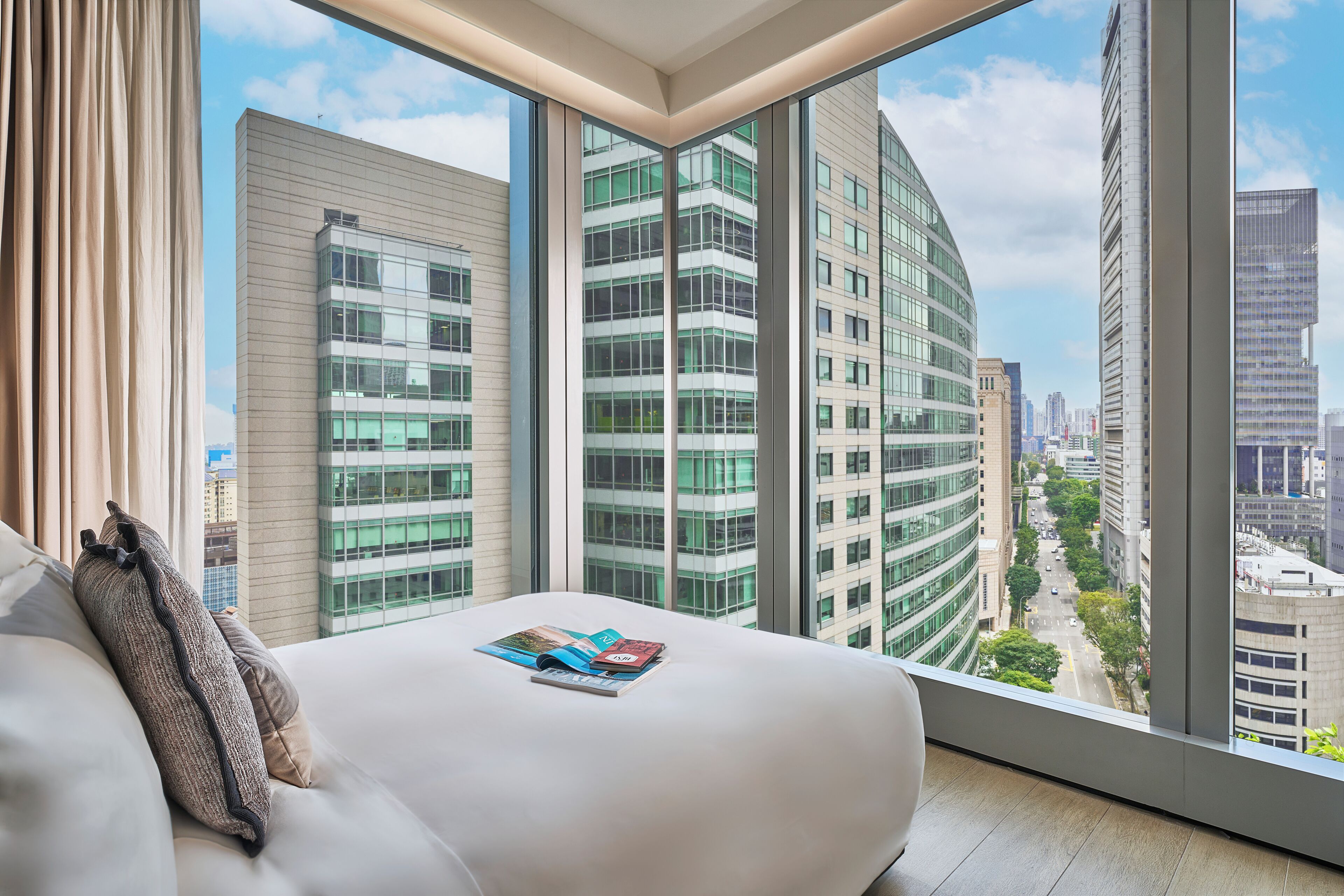 A modern hotel room with a large window offering a city view.