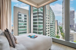 A modern hotel room with a large window offering a city view. - Oakwood Premier Raffles Place Singapore (Singapore)