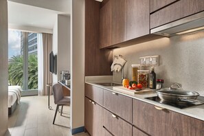 A modern kitchen with a built-in stove, a sink, and a countertop with various kitchen items. - Oakwood Premier Raffles Place Singapore (Singapore)