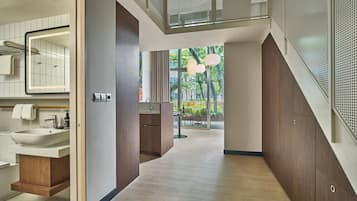 Une salle de bain moderne avec un grand miroir, un lavabo et un meuble-lavabo en bois.