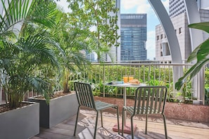 A terrace with two chairs, a table, and potted plants. - Oakwood Premier Raffles Place Singapore (Singapore)