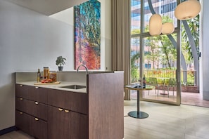 A modern kitchen with a large window, a dining area with a table and chairs, and a colorful abstract painting on the wall. - Oakwood Premier Raffles Place Singapore (Singapore)