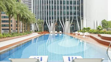 Relax by the pool surrounded by palm trees and lounge chairs.