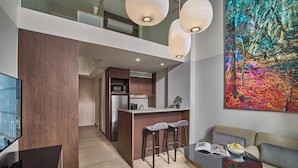 Una cocina moderna con comedor, un sofá y un cuadro abstracto grande.