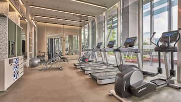 A gym with treadmills, exercise bikes, and weight machines.