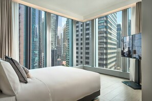 A modern hotel room with a large bed, a flat-screen TV, and a city view through floor-to-ceiling windows. - Oakwood Premier Raffles Place Singapore (Singapore)