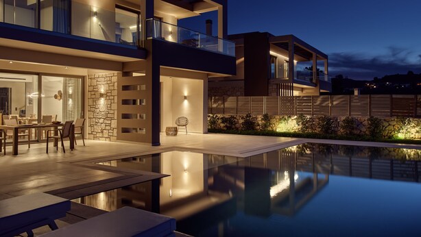 A modern two-story house with a swimming pool, outdoor seating, and a stone wall. - Julieta Villas (Zakynthos)
