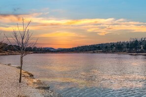 A serene lakeside view with a clear sky and a single tree in the foreground. - Romantic Getaway Near Silver Dollar City with Free Tickets & Onsite Golf Course (Reeds Spring)