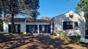 A two-story house with a tiled roof, large windows, and a satellite dish. - Large family house, large garden in an oyster site close to the beach (La perrotine)