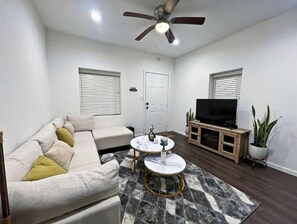 Relax in this inviting living space with a sofa, coffee tables, and a flat-screen TV.