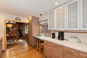 A modern kitchen with wooden cabinets, a coffee maker, and a toaster.