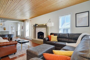 An open spacious living area features a fireplace and plenty of room to get comfortable on the leather sectional, ottoman, and sofa. 