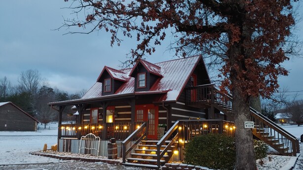 A rustic log cabin with a wooden porch and a staircase leading to a deck. - Bears Valley #171 (Sevierville)