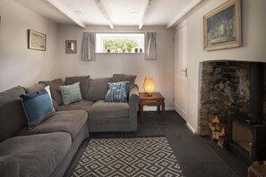A cozy living room with a sectional sofa, a fireplace, and a rug.