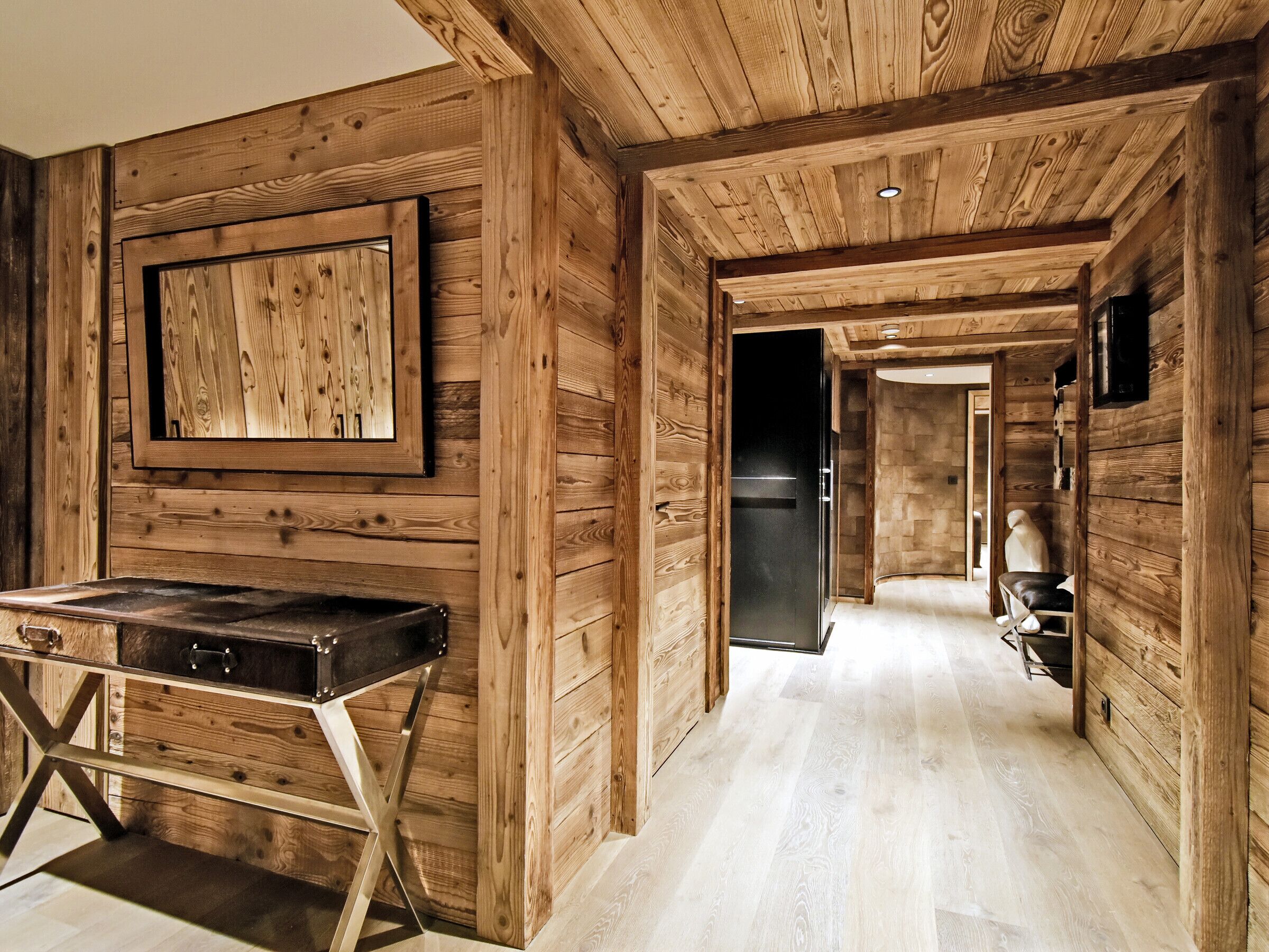 Ein Holzinterieur mit einem Billardtisch, einem gerahmten Kunstwerk und einem durchgehenden offenen Durchgang zur Küche.