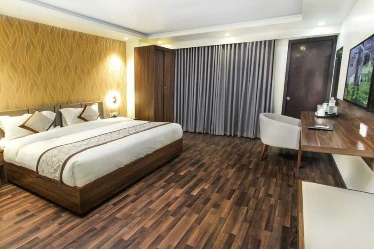 Una habitación de hotel con una cama grande, un escritorio y un televisor.