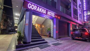 Welcome to the Gorakha Hotel, featuring a grand entrance with stairs and a potted plant.