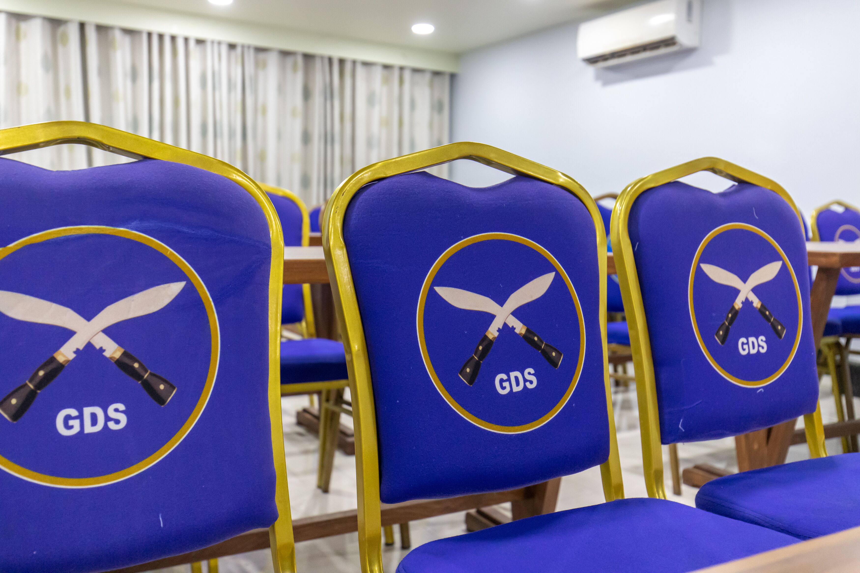 Rows of blue chairs with yellow frames and GDS logos.