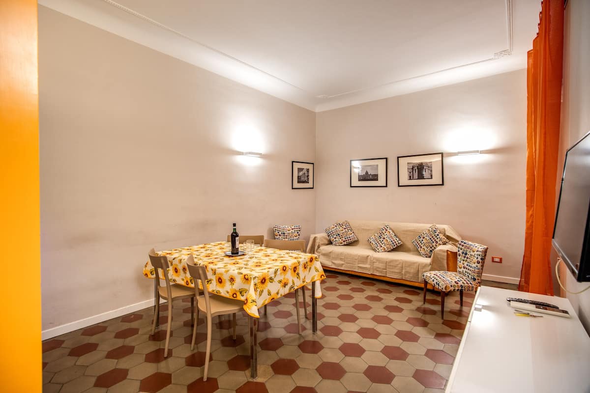 Une pièce comprenant une table à manger, des chaises, un canapé et un téléviseur.