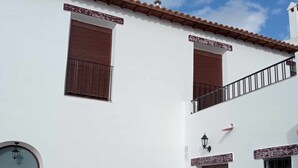 A two-story building with a white facade, brown shutters, and a tiled roof. - Vico rural cave house, ideal for large groups (Freila)