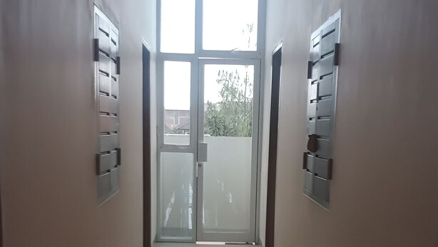 Ein Flur mit einer Glastür, die auf einen Balkon führt.